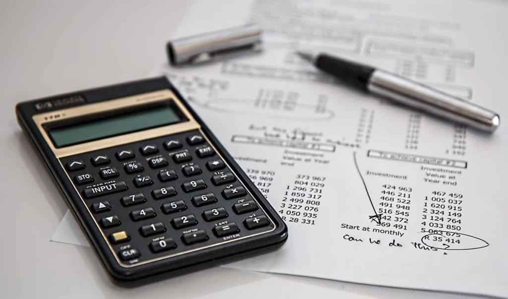 Une calculatrice et des documents financiers pour le calcul assurance.