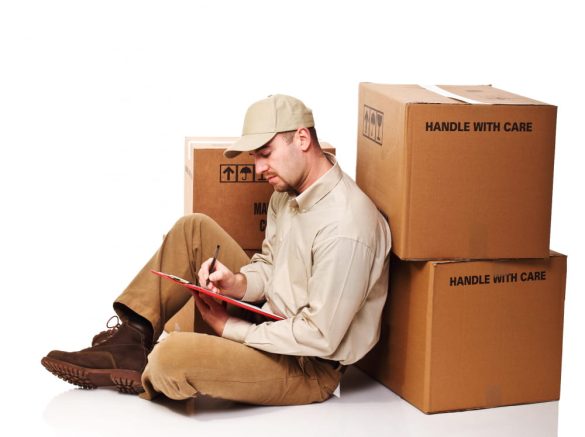 Un professionnel de la logistique vérifie un inventaire sur sa boîte d'expédition lors d'un déménagement de laboratoire