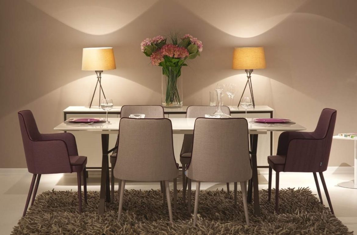 Salle à manger moderne avec une table blanche dressée, deux chaises de salle à manger d'extrémité violettes avec accoudoirs et deux chaises centrales grises.